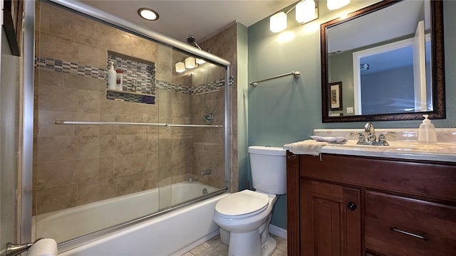 full bathroom featuring tile patterned flooring, vanity, toilet, and shower / bath combination with glass door