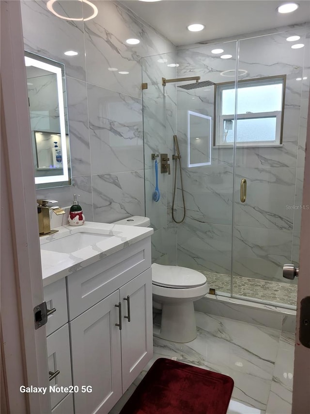 bathroom featuring vanity, toilet, and a shower with shower door