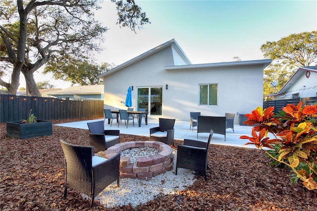 back of house with a fire pit and a patio area