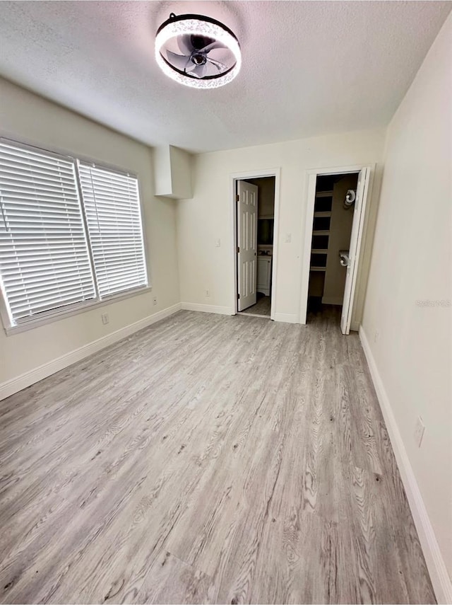 unfurnished bedroom featuring a textured ceiling and light wood-type flooring