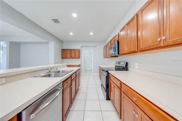 kitchen with light tile patterned floors, sink, and appliances with stainless steel finishes