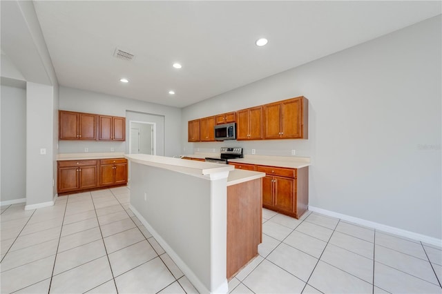 kitchen featuring appliances with stainless steel finishes, a kitchen island, and light tile patterned flooring