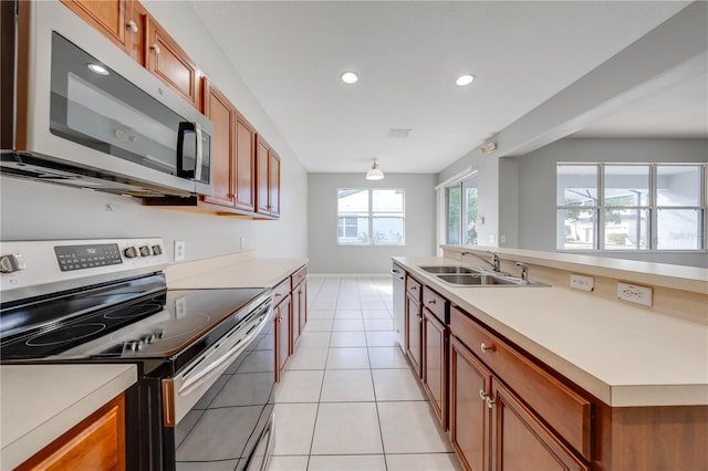 kitchen with light tile patterned floors, stainless steel appliances, and sink