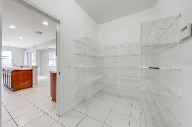 walk in closet featuring sink and light tile patterned floors