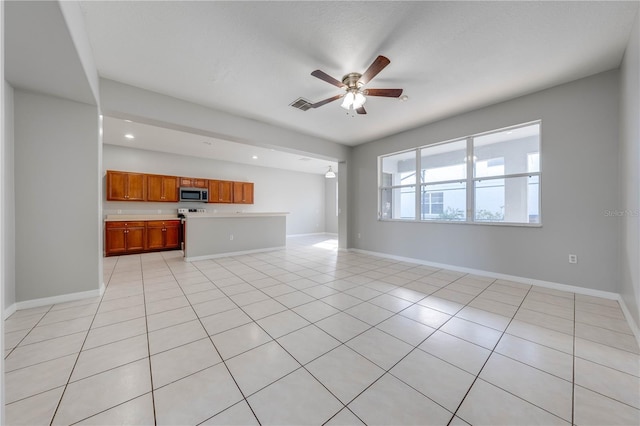 unfurnished living room featuring ceiling fan and light tile patterned floors