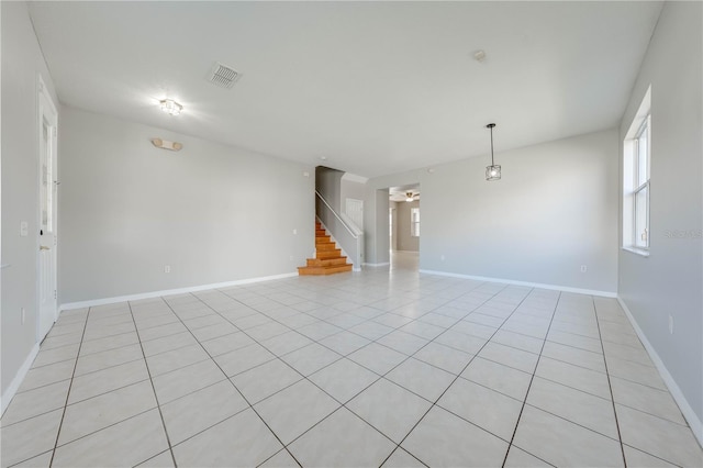 tiled empty room featuring ceiling fan