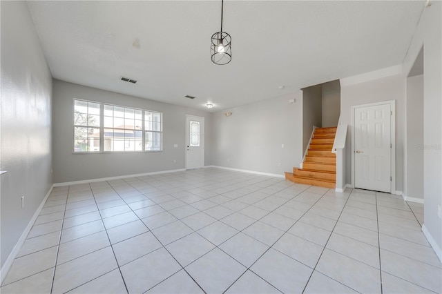 unfurnished room featuring light tile patterned floors and a chandelier