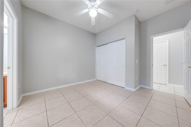 unfurnished bedroom with ceiling fan, light tile patterned flooring, and a closet