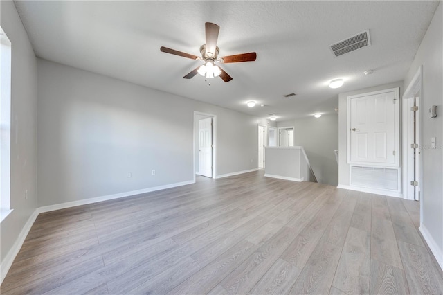 unfurnished room with a textured ceiling, light hardwood / wood-style floors, and ceiling fan