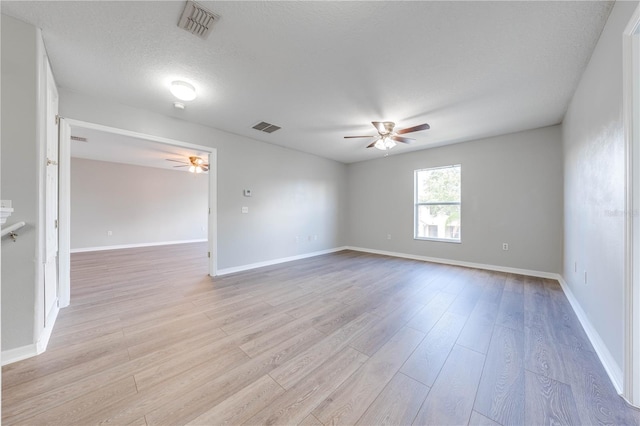 unfurnished room featuring ceiling fan, light hardwood / wood-style flooring, and a textured ceiling