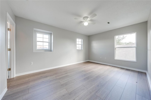 unfurnished room featuring ceiling fan, a healthy amount of sunlight, and light hardwood / wood-style floors