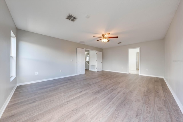 empty room with ceiling fan and light hardwood / wood-style flooring