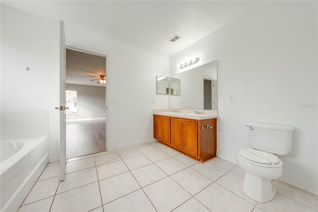 bathroom with ceiling fan, tile patterned flooring, a bath, toilet, and vanity