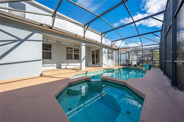 view of swimming pool featuring an in ground hot tub, glass enclosure, and a patio area