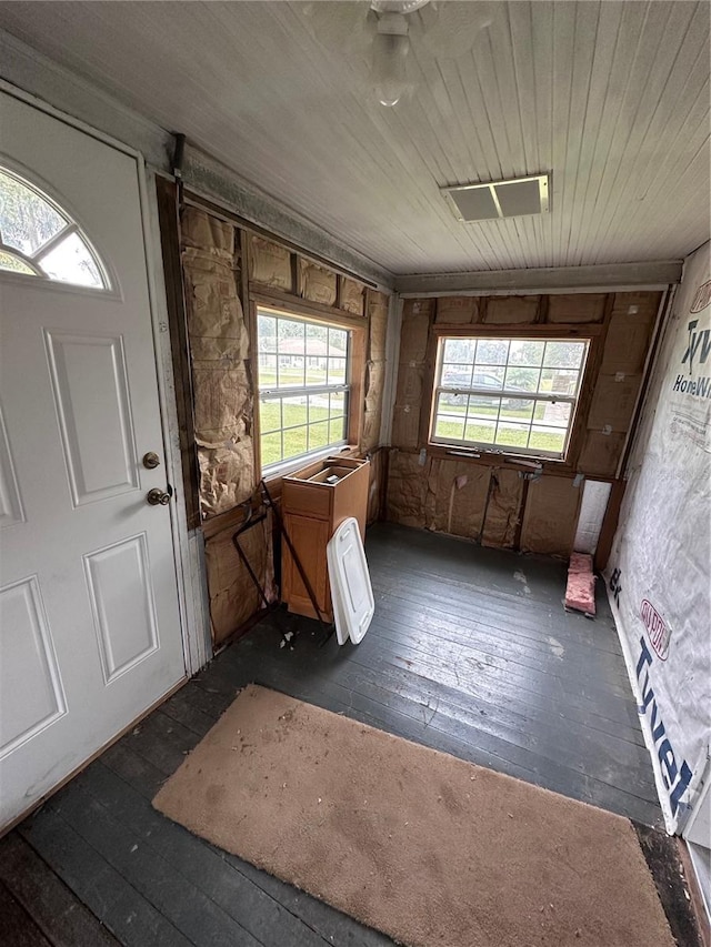 interior space with wooden walls and dark hardwood / wood-style flooring