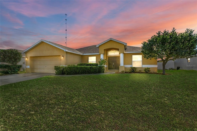 ranch-style home featuring a lawn and a garage