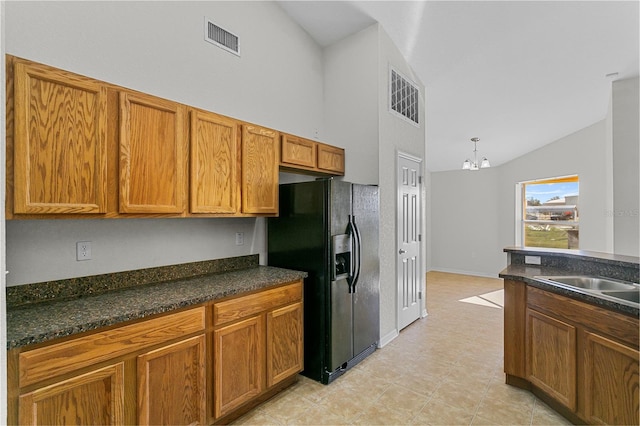 kitchen featuring an inviting chandelier, sink, vaulted ceiling, decorative light fixtures, and black fridge with ice dispenser