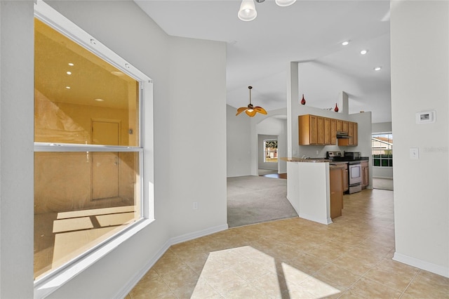 kitchen with stainless steel electric range oven, ceiling fan, high vaulted ceiling, kitchen peninsula, and light carpet