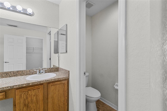 bathroom featuring tile patterned flooring, vanity, and toilet