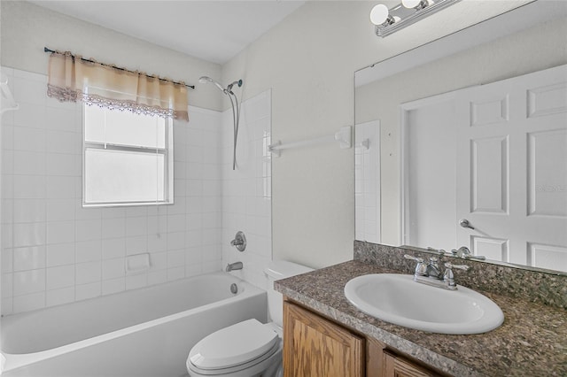 full bathroom with tiled shower / bath, vanity, and toilet