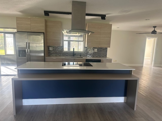 kitchen featuring hardwood / wood-style floors, a center island, island range hood, and sink