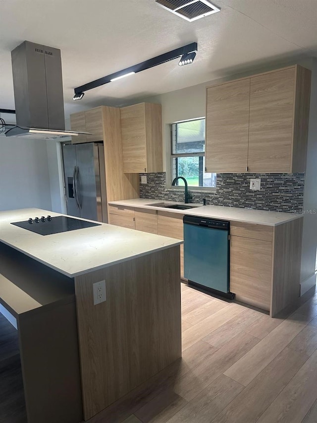 kitchen with a center island, ventilation hood, sink, light hardwood / wood-style flooring, and appliances with stainless steel finishes