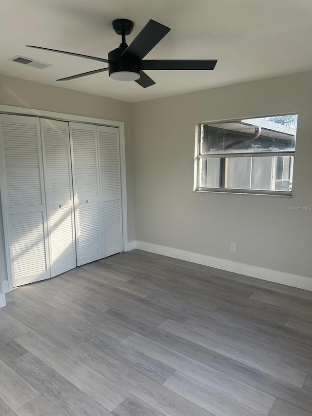 unfurnished bedroom featuring ceiling fan, a closet, and light hardwood / wood-style floors