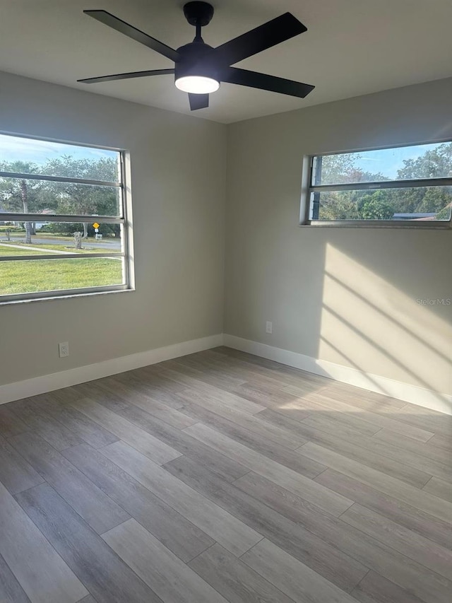 spare room featuring light hardwood / wood-style flooring, plenty of natural light, and ceiling fan