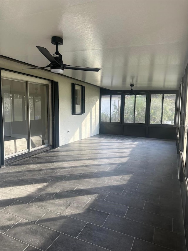 unfurnished sunroom with ceiling fan