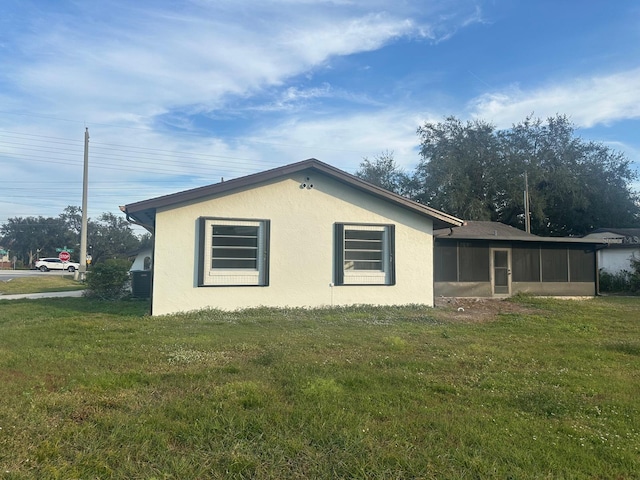 view of side of property featuring a yard and a sunroom