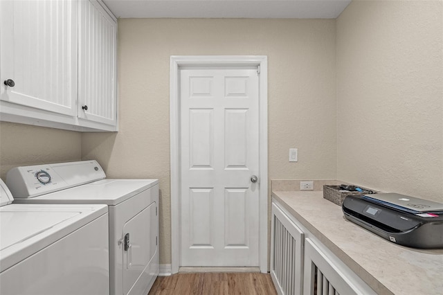 laundry area with cabinets, independent washer and dryer, and light hardwood / wood-style flooring