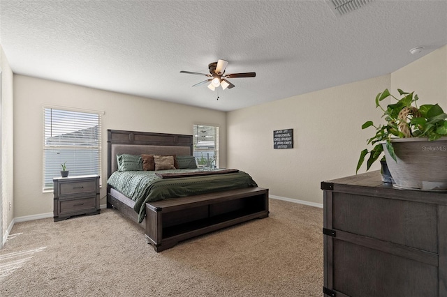 bedroom featuring a textured ceiling, ceiling fan, and light carpet