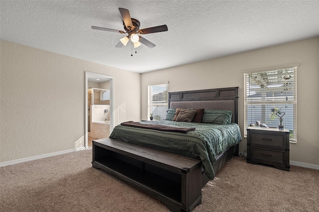 carpeted bedroom featuring a textured ceiling, ensuite bathroom, multiple windows, and ceiling fan