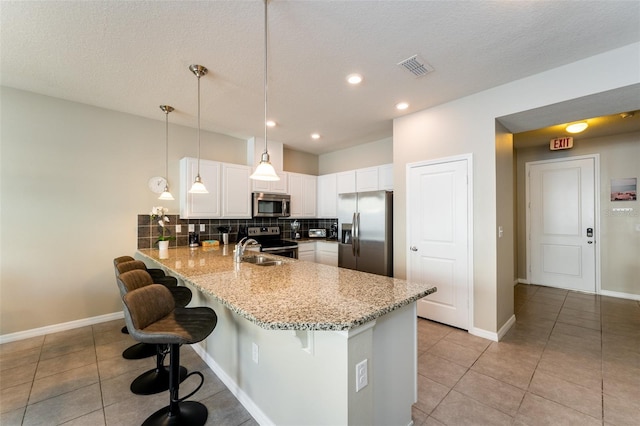 kitchen featuring kitchen peninsula, sink, a textured ceiling, appliances with stainless steel finishes, and white cabinetry