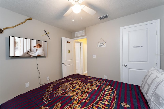 bedroom with ceiling fan and a textured ceiling