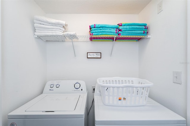 laundry room featuring a textured ceiling and washing machine and clothes dryer