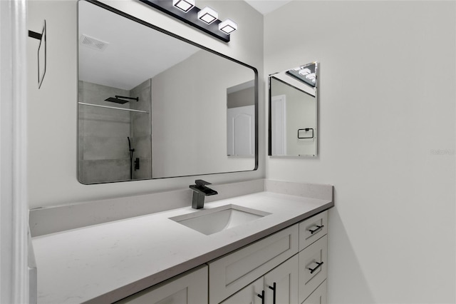 bathroom featuring vanity and tiled shower