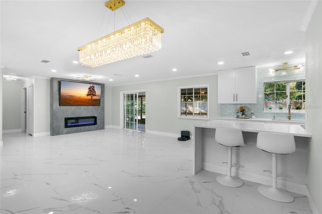 kitchen featuring white cabinets, decorative light fixtures, an inviting chandelier, and a wealth of natural light