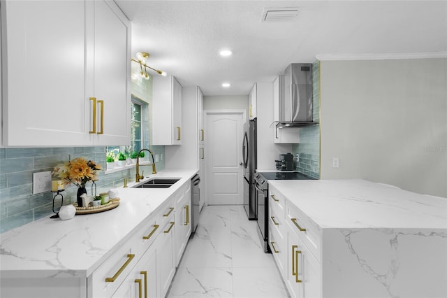 kitchen with sink, wall chimney exhaust hood, stainless steel appliances, backsplash, and white cabinets