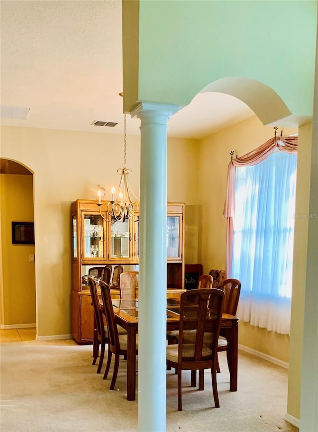 carpeted dining space with an inviting chandelier