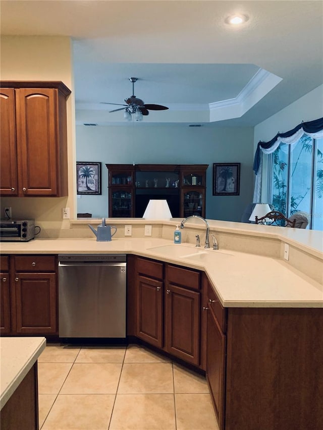 kitchen with dishwasher, ceiling fan, sink, light tile patterned floors, and a tray ceiling