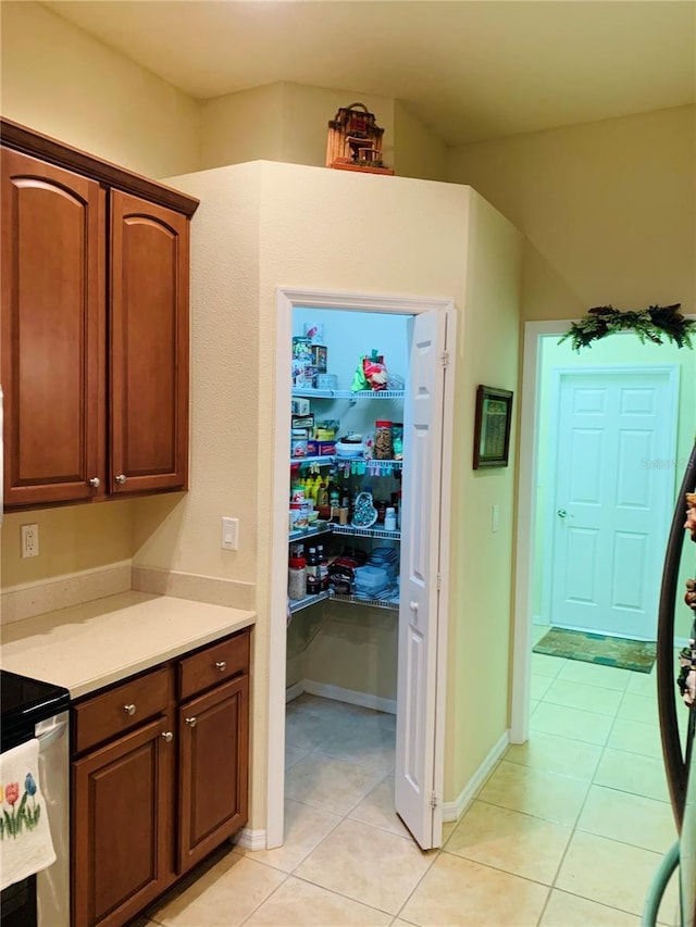 kitchen featuring light tile patterned floors and range with electric cooktop