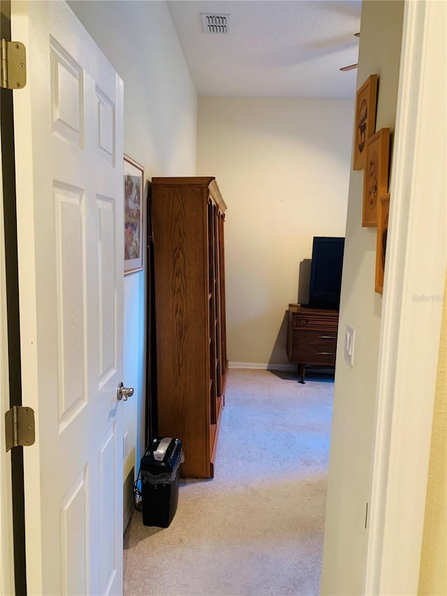 hallway featuring light colored carpet