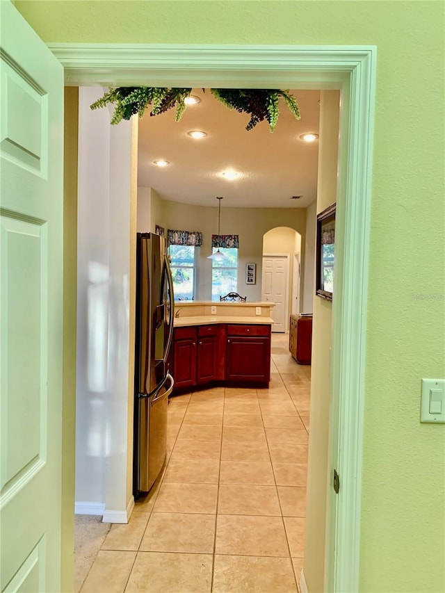 kitchen with decorative light fixtures, light tile patterned floors, and stainless steel fridge