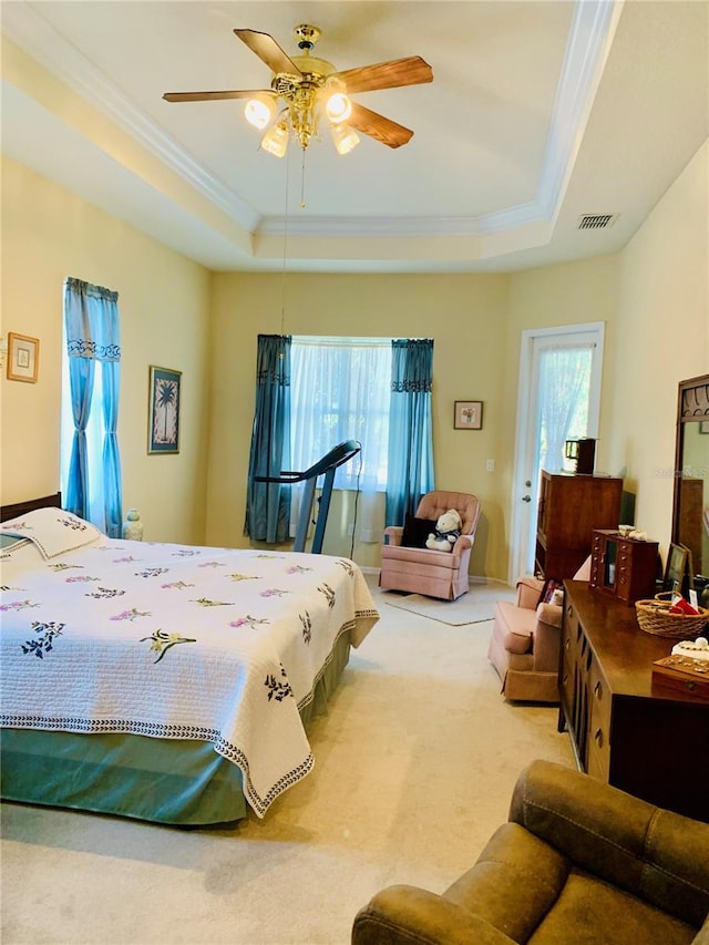 bedroom featuring ceiling fan, carpet, a tray ceiling, and crown molding