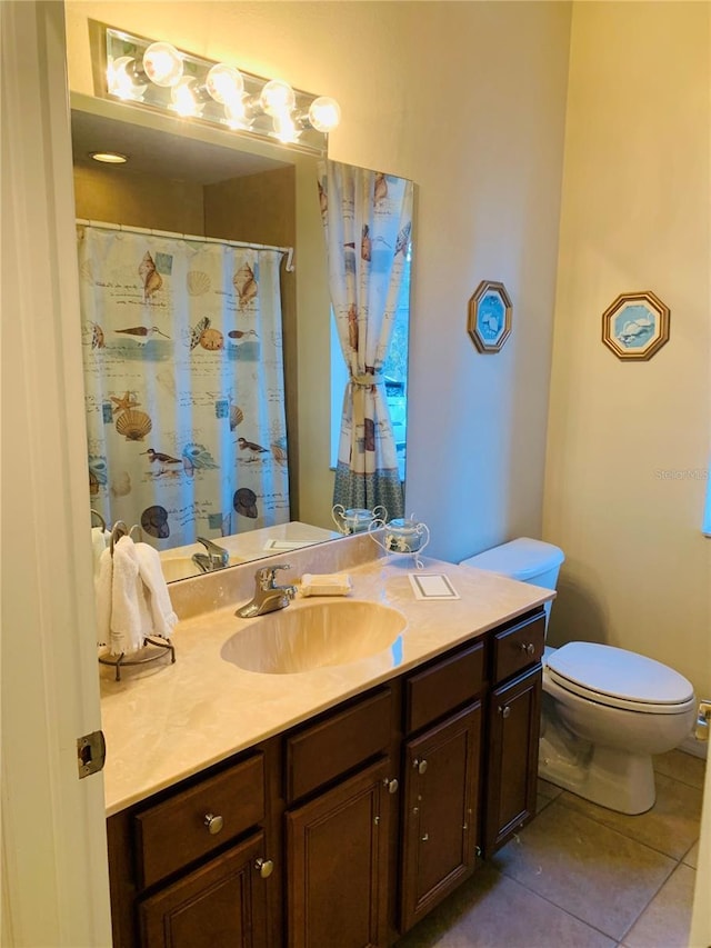 bathroom featuring toilet, vanity, and tile patterned flooring