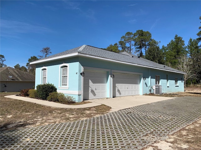 view of side of property featuring central air condition unit and a garage