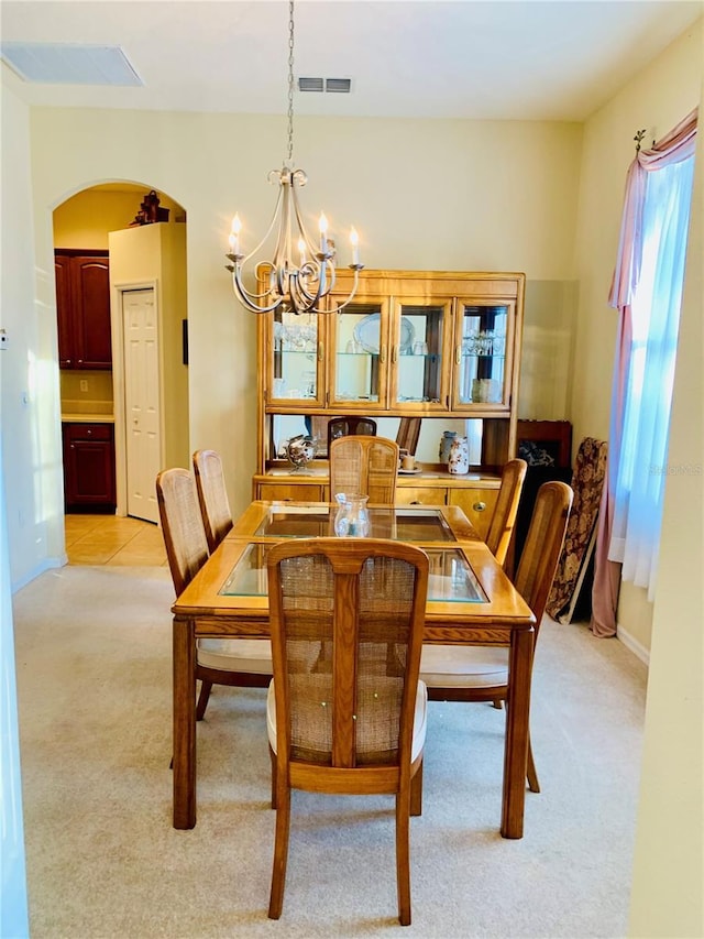 carpeted dining room with a chandelier