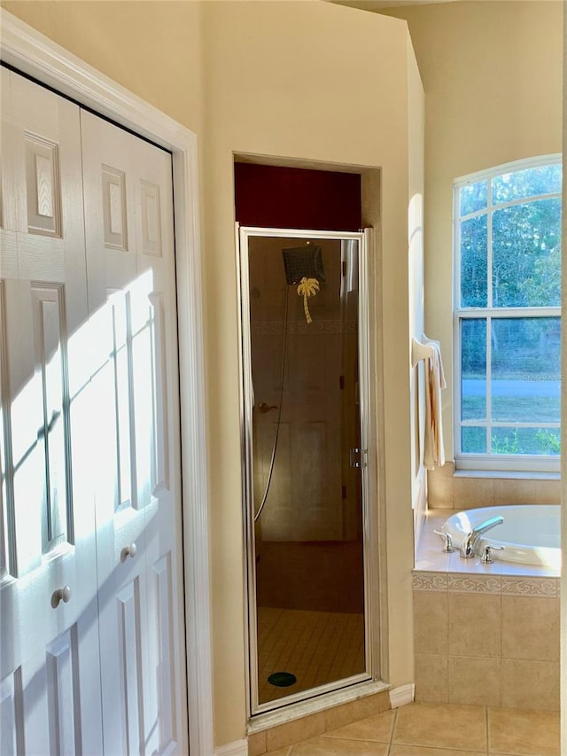 bathroom featuring separate shower and tub, tile patterned floors, and a healthy amount of sunlight