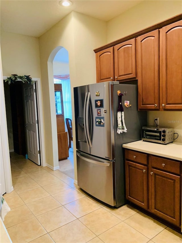 kitchen with light tile patterned floors and stainless steel fridge with ice dispenser